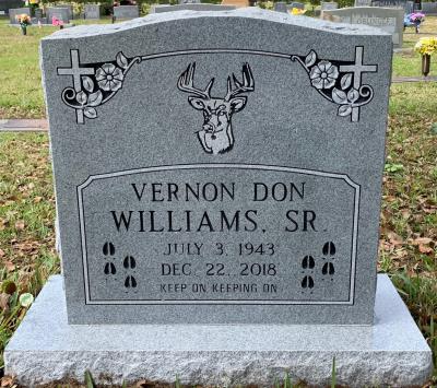 granite upright headstone with a buck deer emblem and deer tracks